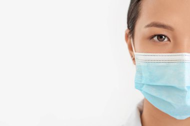 Hafif arka planda tıbbi maskeli kadın Asyalı doktorun portresi