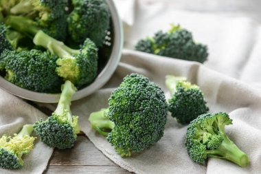 Kumaş zemin üzerinde taze brokoli lahanası olan kolander.