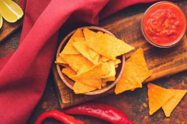 Lezzetli nachos ve arkaplanda sos olan bir pano.