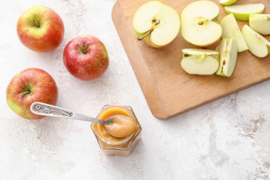 Kavanoz dolusu tatlı elma reçeli ve hafif arka planda kaşık