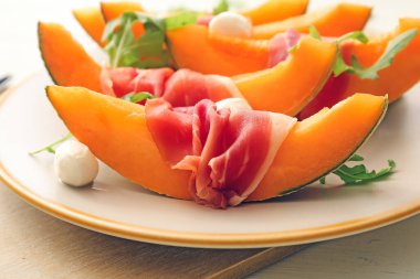 Lezzetli kavun, mozzarella ve prosciutto tabağı, yakın plan.