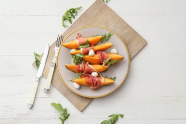 Nefis kavunlu tabak, mozzarella ve arka planda jambon.