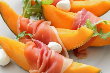 Lezzetli kavun, mozzarella ve prosciutto tabağı, yakın plan.