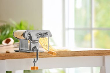 Mutfaktaki masada hamurlu makarna makinesi.