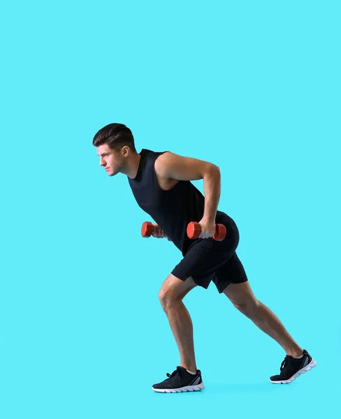 Joven Deportivo Entrenando Con Pesas Sobre Fondo Color — Foto de Stock