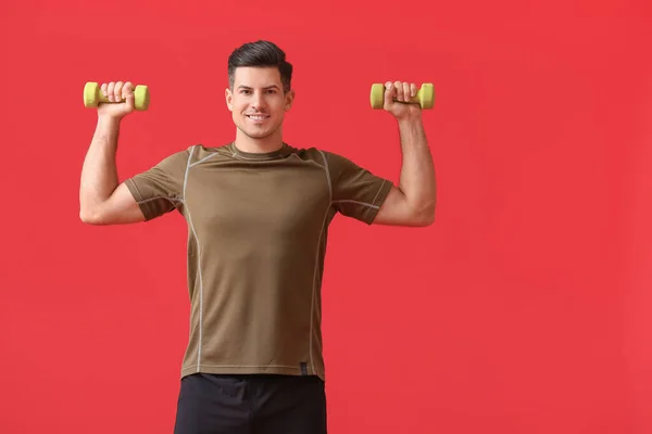 Joven Deportivo Entrenando Con Pesas Sobre Fondo Color — Foto de Stock