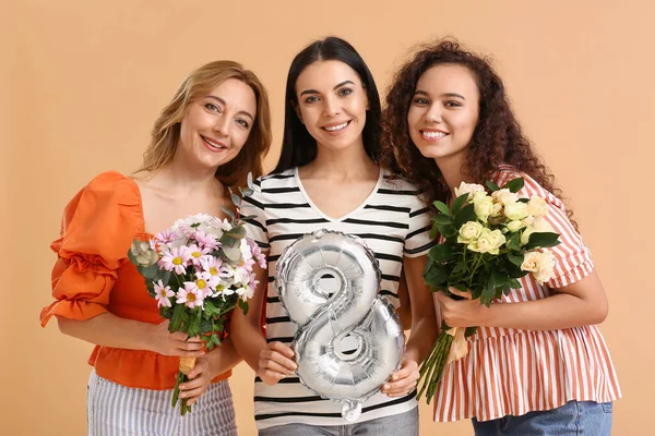 Beautiful women with flowers and balloon on color background. International Women\'s Day celebration