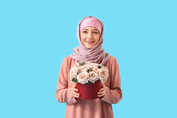 色の背景に花を持つ美しい成熟したイスラム教徒の女性 国際女性デーのお祝い — ストック写真