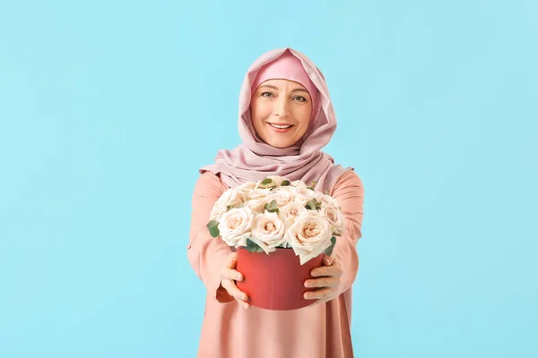 色の背景に花を持つ美しい成熟したイスラム教徒の女性 国際女性デーのお祝い — ストック写真