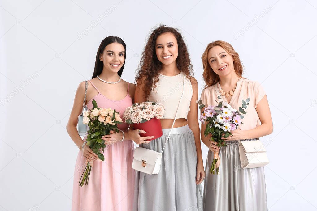 Beautiful women with flowers on white background. International Women's Day celebration