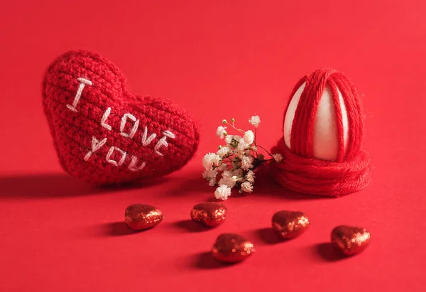 Creative Easter egg, heart and candies on color background