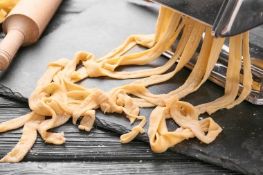 Ahşap arka planda hamurlu makarna makinesi