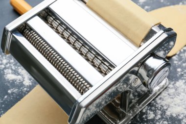 Koyu arkaplanda hamurlu makarna makinesi
