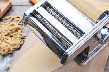 Ahşap arka planda hamurlu makarna makinesi