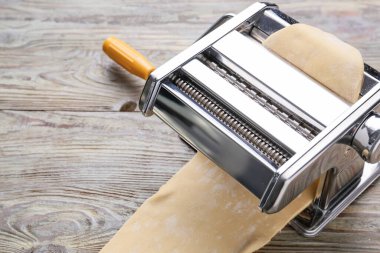 Ahşap arka planda hamurlu makarna makinesi