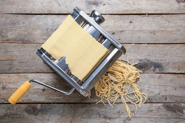 stock image Pasta machine with dough on wooden background