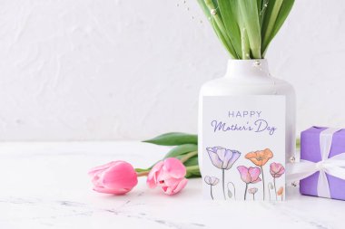 Anneler Günü için arkaplanda güzel çiçekler, hediye ve tebrik kartı.