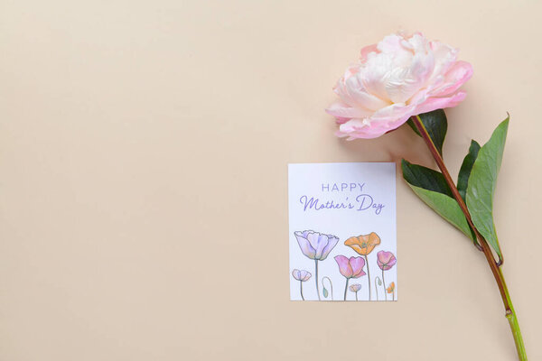 Beautiful flower and greeting card for Mother's Day on color background