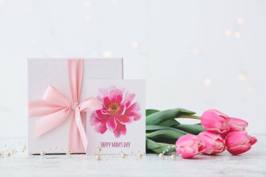 Anneler Günü için arkaplanda güzel çiçekler, hediye ve tebrik kartı.