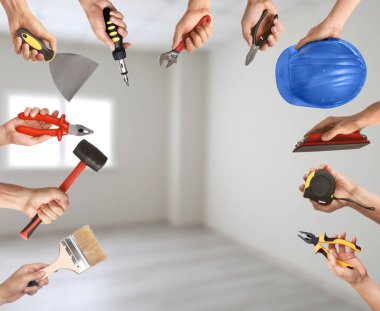 İçerde farklı inşaat aletleri olan birçok el.