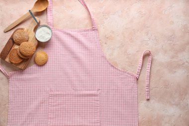 Önlük, un ve arkaplanda lezzetli kurabiyeler