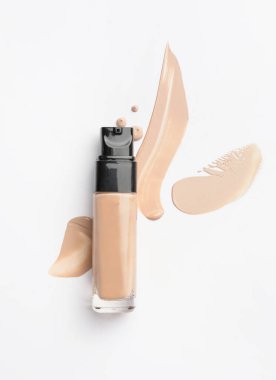 Bir şişe makyaj vakfı ve beyaz arkaplanda örnekler