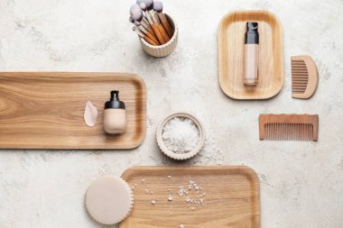 Makyaj malzemeleri, fırçalar ve arka planda saç tarakları.