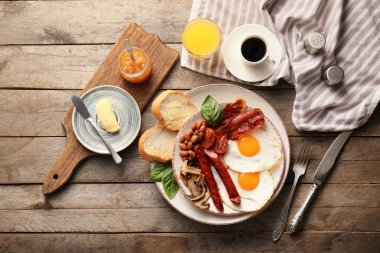 Geleneksel İngiliz kahvaltısı ve ahşap arka planda sahanda yumurta.