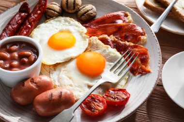 Geleneksel İngiliz kahvaltısı ve ahşap arka planda kızarmış yumurta.