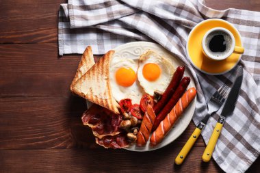 Geleneksel İngiliz kahvaltısı ve ahşap arka planda kızarmış yumurta.