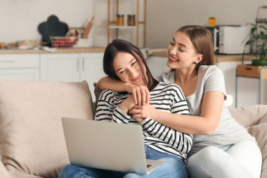 Genç lezbiyen çift evde arkadaşlarıyla görüntülü sohbet ediyor.