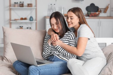 Genç lezbiyen çift evde arkadaşlarıyla görüntülü sohbet ediyor.