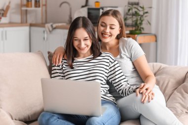 Genç lezbiyen çift evde arkadaşlarıyla görüntülü sohbet ediyor.