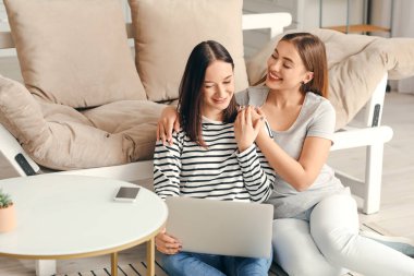 Genç lezbiyen çift evde arkadaşlarıyla görüntülü sohbet ediyor.