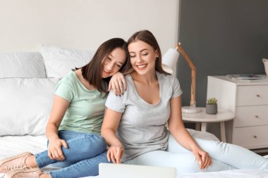 Genç lezbiyen çift evde arkadaşlarıyla görüntülü sohbet ediyor.