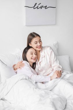 Genç lezbiyen çift yatakta dinleniyor.