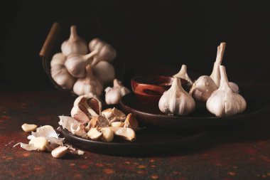 Arka planda taze sarımsaklı tabaklar.