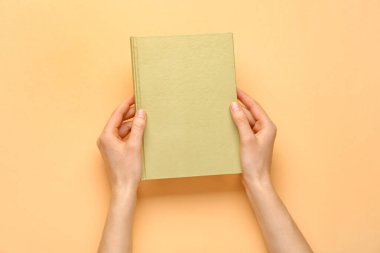 Renk arkaplanı hakkında boş kitabı olan kadın elleri