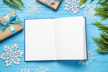 Renkli ahşap zemin üzerine boş bir kitapla Noel kompozisyonu