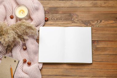 Boş kitap, fındık ve ahşap zemin üzerinde mum.