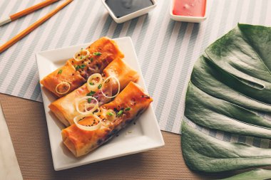 Lezzetli kızarmış börek ve soslu bir tabak.