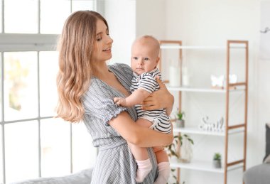 Mutlu anne ve evde küçük şirin bir bebek.