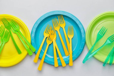 Açık arkaplanda plastik çatallar ve plakalar