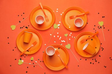 Renkli arkaplanda plastik sofra takımı ve konfeti