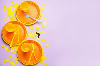 Renkli arkaplanda plastik sofra takımı ve konfeti