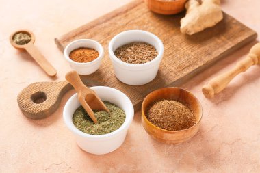 Renkli arka planda farklı baharatlı kase ve kepçeler