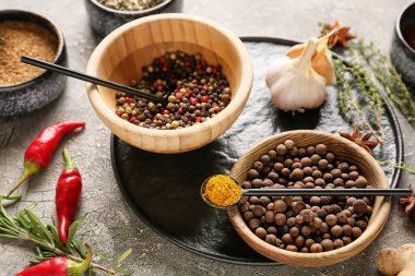 Koyu arkaplanda farklı baharatlar bulunan kaseler, yakın plan