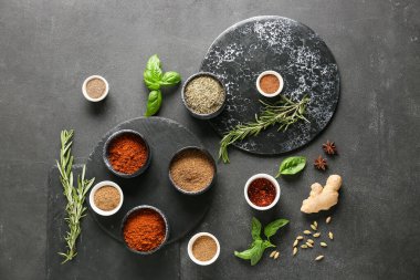 Koyu arkaplanda farklı baharatlar bulunan kaseler