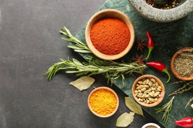 Koyu arkaplanda farklı baharatlar bulunan kaseler
