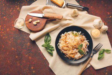 Lezzetli erişteli tabak, tavuk ve arkaplanda malzemeler.